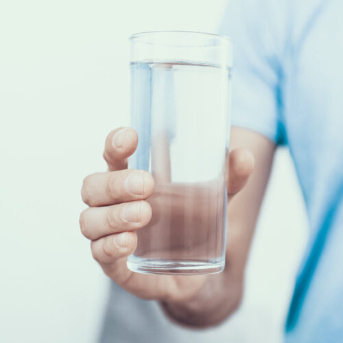 close-up of someone holding a glass of clean water